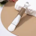 Close-up of double-ended facial mask brush with rhinestone handle and soft white bristles. - Soft Brush / Khaki