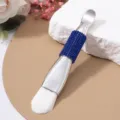 Close-up detail of double-headed silver mask brush with blue rhinestone handle and soft bristles - Soft Brush / Sapphire Blue