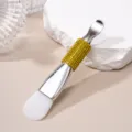 Detailed macro view of double-ended silicone facial mask brush with yellow rhinestone handle - Silicone Brush / Yellow