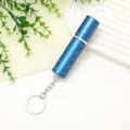 Close-up of a stylish blue 10ml mini refillable perfume atomizer with a silver keychain. - Blue