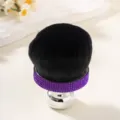 Close-up of soft black mushroom makeup brush with purple rhinestone band detail - Deep purple