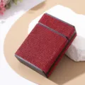 Close-up of luxury red rhinestone-encrusted cigarette case on a decorative white stone - Red