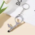 Detailed view of the sparkling rhinestone-encrusted no-touch door opener keychain. - Silver