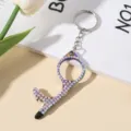 Close-up of the double-sided sparkling rhinestone portable door opener keychain tool. - Iridescent
