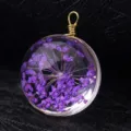Macro view of handmade glass pendant charm containing vibrant purple dried flowers - Gold Wire (P2015) / 15mm Diameter / Purple