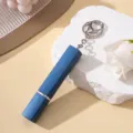 Détail macro d'un atomiseur de parfum bleu 12ml avec finition texturée et porte-clés - Bleu
