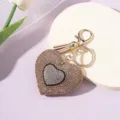 Detailed view of the sparkling rhinestone heart keychain with a stylish tan tassel. - Khaki