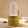 Macro view of luxurious golden rhinestone makeup brush holder with a clear dome lid - Yellow