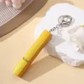 Détail d'un atomiseur de parfum doré de 12 ml avec un porte-clés argenté élégant - Or