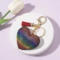 Close-up of rainbow rhinestone heart keychain with burgundy tassel and gold hardware. - Colorful