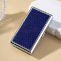 Detailed macro view of a silver metal cigarette case fully inlaid with sparkling blue rhinestones - Sapphire Blue