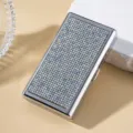 Detailed close-up showing iridescent rhinestones on a sleek silver metal cigarette case - AB White