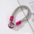 Detailansicht einer silbernen Strass-Handy-Handschlaufe mit magentafarbenen Akzenten. - Rhinestone Phone Wristlet / Fuchsia