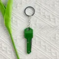 Detail view of a green key-shaped folding mini knife keychain for outdoor unboxing - Green