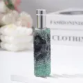 Detail view of a 10ml glass perfume spray bottle encrusted with green rhinestones - 10ml / Green Python