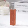 Detail shot of a 10ml portable perfume spray bottle decorated with sparkling orange rhinestones. - 10ml / Orange Red