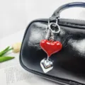 Red and silver heart-shaped pendant keychain charm hanging on a black leather bag - Heart Pendant (02) / Red