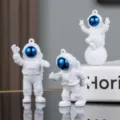 Detailed close-up view of cute PVC astronaut keychains with blue visors and hanging rings. - 3-Piece Set without Buckle / Blue