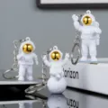 Cute astronaut keychain detail, PVC space man pendant and creative metal keyring for gifts. - 3-Piece Set with Buckle / Gold