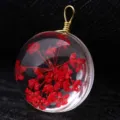 Macro view showing a clear resin pendant with red dried flowers and a gold wire loop. - Gold Wire (P2018) / 15mm Diameter / Red