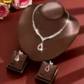 Close-up detail of a stunning rhinestone necklace and teardrop red earrings jewelry set display. - Two-Piece Set / Red