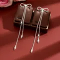 Stunning sparkling rhinestone bow long tassel earrings detail view, elegant luxury jewelry design. - Silver