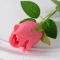 Close-up of a single pink silk artificial rosebud for wedding decoration - Watermelon red