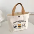Detailed view of white canvas tote bag with cute cartoon bear print and brown handles. - 26x22cm / Random Style