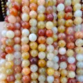 Vue macro montrant en détail la texture brillante des perles d'agate translucides colorées - 6mm / Jade de Quartzite