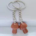 Close-up of sparkling goldstone mushroom keychain charm, perfect bag accessory detail view. - Synthetic Goldstone