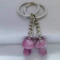 Detail shot of natural crystal pink mushroom keychain charm, cute stone key ring bag accessory. - Lilac
