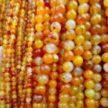 Close-up view of vibrant yellow and orange agate gemstone beads, perfect for DIY jewelry making. - 4mm / Orange-Red Striped Agate