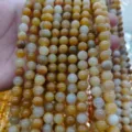 Primo piano di perline in pietra naturale con ricche variazioni di colore giallo e bianco. - Pietra Gialla