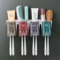 Wall-mounted toothbrush holder set with four cups and storage rack for bathroom organization. - Four-Slot Automatic Toothpaste Dispenser