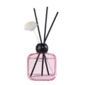 Pink glass bottle reed diffuser with black sticks and flower for home fragrance air freshener. - Four Seasons Encounter