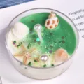 Handgemaakte oceaan geurkaars met schelpen en zeesterren in transparante glazen beker - Schelpenpailletten - Groen [Limoenverbena] / Ongeveer 30g