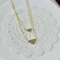 Elegante doppellagige Goldhalskette mit funkelnden dreieckigen CZ-Pflasteranhängern - Doppelschichtiges Dreieck-Stil / Gold
