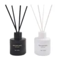 Detailed view of black and white reed diffuser bottles with sticks, set of home fragrances. - Two-Bottle Set (Ebony Sandalwood/Westin White Tea)