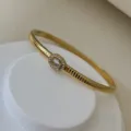 Eleganter vergoldeter Edelstahlreif mit ovalem Zirkonia und Gewindestruktur - Oval-Stil (4mm) / Gold