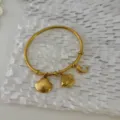 Eleganter goldener Edelstahl-Armreif mit Muschel-, Fisch- und Delphin-Anhängern - Muschel-Delfin-Anhänger-Stil / Gold