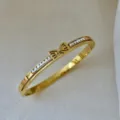 Elegante bracciale rigido in acciaio inossidabile placcato oro 18K con fiocco di zirconi - Stile Fiocco Piccolo Strass