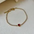 Elegantes vergoldetes Armband mit Zirkonia und einem leuchtend roten Herz-Edelstein. - Rotes Herz Stil
