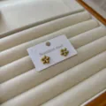 Kleine vergoldete Gänseblümchen-Ohrstecker mit einem funkelnden Kristallzentrum - Gänseblümchen / Gold