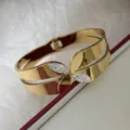 Eleganter goldener Manschettenarmreif aus Titanstahl mit Kristall-Blattmotiven - Vierblättriges Kleeblatt Stil / Gold