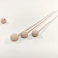 Detailed close-up of wooden aroma diffuser sticks with textured spherical heads and beads. - Threaded Wooden Bead with Rattan