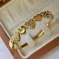 18K vergoldetes Edelstahl-Herzarmband mit funkelnder Strassstein-Einlage - Drei Herzen Strass Stil / 60mm Innendurchmesser