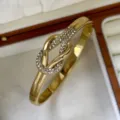 Eleganter 18k vergoldeter Edelstahl-Armreif mit einem funkelnden Kristallknoten-Design - Gekreuzter Knoten-Stil / Gold