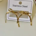 Elegante Ohrringe aus 18k vergoldetem Edelstahl in Schleifenform auf Displaykarte - Flache Schlangenkette Schleifenohrringe / Gold