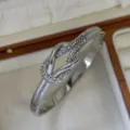 Silver knotted stainless steel bangle featuring sparkling pavé crystals in a luxury box - Crossed Knot Style / Silver
