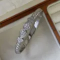 Elegant silver-colored twisted cable bangle featuring teardrop zircon pavé details in a jewelry box - Waterdrop Style / Silver